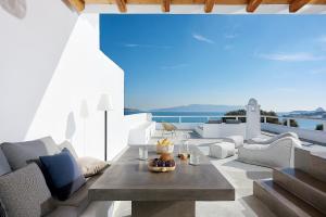 a living room with white furniture and a table at Litore Suite in Pollonia