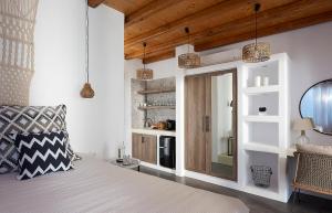 a bedroom with white walls and wooden ceilings and a bed at Litore Suite in Pollonia