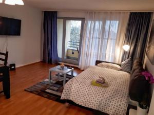 ein Wohnzimmer mit einem Bett und einem Tisch in der Unterkunft 2-Zimmerapartment mit Südloggia in Leipzig