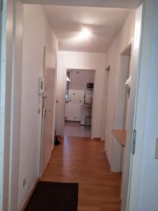 um corredor de um apartamento com paredes brancas e pisos de madeira em 2-Zimmerapartment mit Südloggia em Leipzig