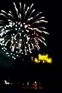 um fogo de artifício à noite com um edifício ao fundo em Romantic-Pension Albrecht - since 1901 em Hohenschwangau