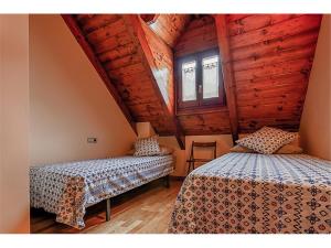 1 Schlafzimmer mit 2 Betten in einer Holzhütte in der Unterkunft Saplan Real Estate ARTIGA in Les Bordes