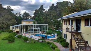 a house with a swimming pool in a yard at Las Lomas Suites & Spa in Chascomús