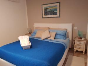 een bed met blauwe lakens en kussens in een slaapkamer bij Appartamento mansardato Anda&Torra in Castelsardo