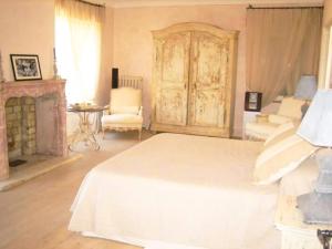 a bedroom with a white bed and a fireplace at Villa Virginie in Saint-Tropez