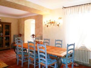 a dining room with a wooden table and blue chairs at Villa Virginie in Saint-Tropez