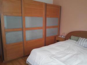 ein Schlafzimmer mit einem großen Holzschrank und einem Bett in der Unterkunft Ferienwohnung ZENTRAL in Eisenach