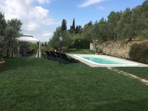 une cour avec une piscine, une table et des chaises dans l'établissement Villa al Castello Florence View, à Calenzano