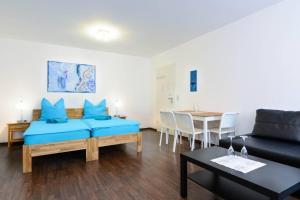 Private rooms next to subway في نورنبرغ: غرفة معيشة مع أريكة زرقاء وطاولة