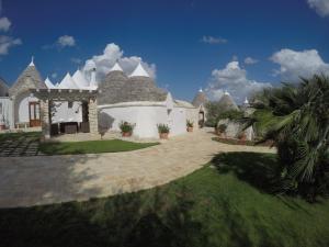 a large white house with a palm tree at Masseria Cappuccini in Ostuni