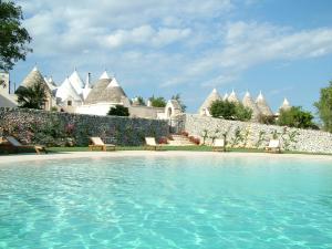 a resort with a swimming pool in front of a building at Masseria Cappuccini in Ostuni