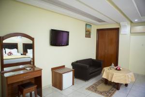 Zimmer mit einem Bett, einem Stuhl und einem Tisch in der Unterkunft Hotel Gomassine in Marrakesch