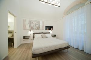 una camera bianca con un letto e una grande finestra di Sotrani a Trani