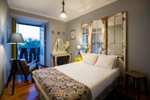 um quarto com uma cama, uma mesa e uma janela em Ola Lisbon -Alfama I em Lisboa