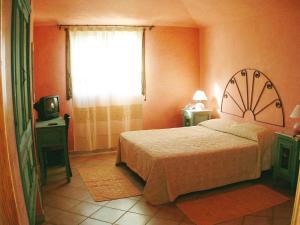 a bedroom with a bed and a window and a television at Principessa de Navarra in Santa Maria Navarrese