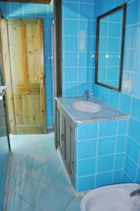 a blue tiled bathroom with a sink and a mirror at Principessa de Navarra in Santa Maria Navarrese +53 photos