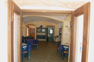 a dining room with blue tables and chairs at Principessa de Navarra in Santa Maria Navarrese