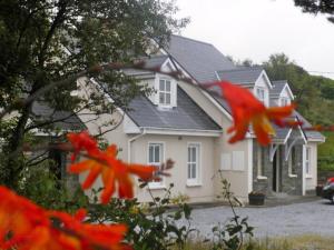 a white house with red birds flying in front of it at Earlscourt in Glenbeigh