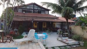 萨夸雷马Hostel Lagoa do Sol的一间房子，前面有一张桌子和几把椅子