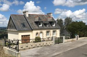 ein kleines weißes Haus mit schwarzem Dach in der Unterkunft Maison entre terre et mer in Gouézec