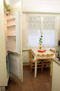 uma cozinha com uma mesa, uma mesa e um frigorífico em Relax e mare em Savona