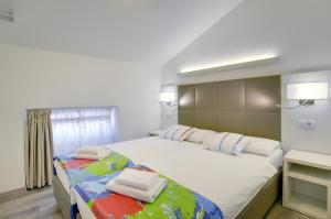 a bedroom with a large white bed with towels on it at Boutique Suites Joyce in Pula