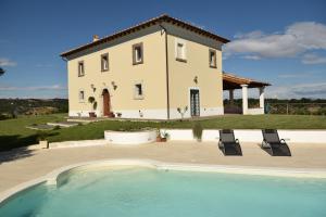 a villa with a swimming pool in front of a house at Tenuta Donna Caterina in Tessennano