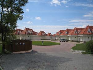 a row of houses with red roofs on a driveway at Gólya Villa Park in Velence