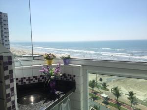 ein Bad mit einem Waschbecken und Blick auf den Strand in der Unterkunft Apartamento Cheryl in Praia Grande