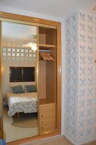 貝尼多姆的住宿－Ruzafa Rincon Español，卧室前的镜子,卧室配有一张床