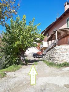 un árbol con una flecha apuntando a una casa en Affittacamere DaMammaSara, en Rignano sullʼArno