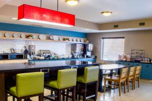 a kitchen with a bar with green chairs at Country Inn & Suites by Radisson, Dayton South, OH in Dayton