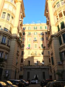 Un grand bâtiment avec des voitures garées devant lui dans l'établissement Santa Caterina B&B, à Naples