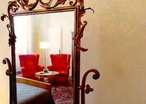 a mirror in a room with two chairs and a table at Hotel Cestelli in Florence
