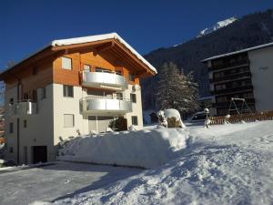 a building with a balcony in the snow at Haus Artemis in Saas-Grund
