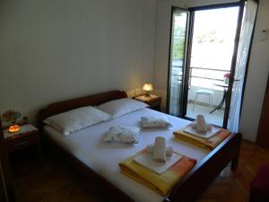 a bedroom with a bed with towels and a window at Ema in Brela