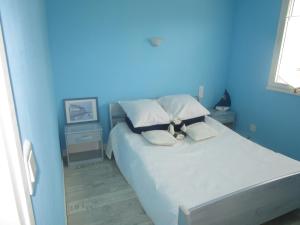 Maison proche Mont St Michel et St Malo في روز سور كوسنون: غرفة نوم زرقاء مع سرير كبير مع الوسائد
