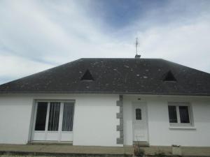 una casa blanca con techo negro en Maison proche Mont St Michel et St Malo en Roz-sur-Couesnon