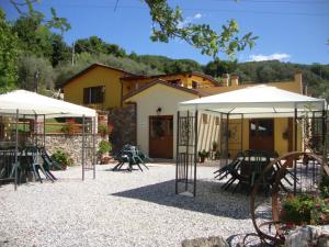 a patio with tables and umbrellas in front of a building at Agriturismo La Sarticola in Luni