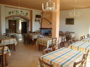 a restaurant with tables and chairs and a chandelier at Agriturismo La Sarticola in Luni