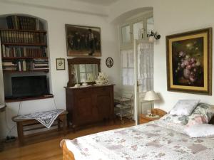 a bedroom with a bed and a dresser and a television at Villa-Magdi Vendégház in Révfülöp