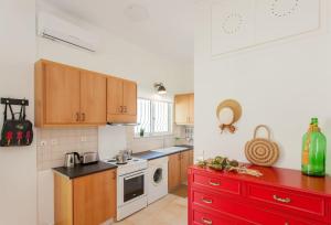 uma cozinha com armários de madeira e uma bancada vermelha em Rena House em Kissamos