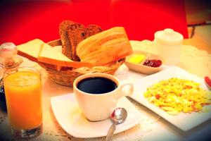 einen Tisch mit einem Teller Brot und einer Tasse Kaffee in der Unterkunft Ruta Hotel Alto La Cruz in Los Ángeles