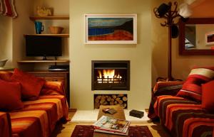 a living room with a fireplace and two couches at Hang Your Hat in Winchester