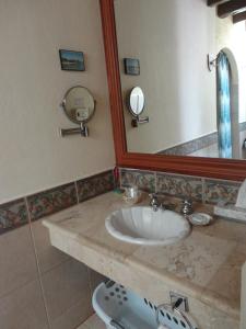 a bathroom with a sink and a mirror at Hotel Hacienda Flamingos in San Blas