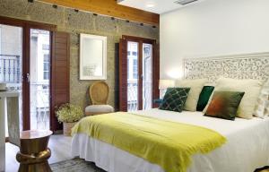 Un dormitorio con una cama grande con una manta amarilla. en Numa Rúa Travesa, en Santiago de Compostela