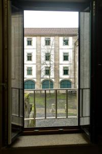 Una ventana abierta con vista a un edificio en Numa Rúa Travesa, en Santiago de Compostela