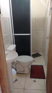 a bathroom with a toilet and a sink at Pousada Porto Guará in Guaratuba