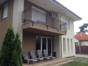 a group of chairs sitting under a balcony at Molo Wellness Garden in Siófok