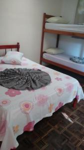 a bedroom with a bed with a blanket on it at Pousada Porto Guará in Guaratuba